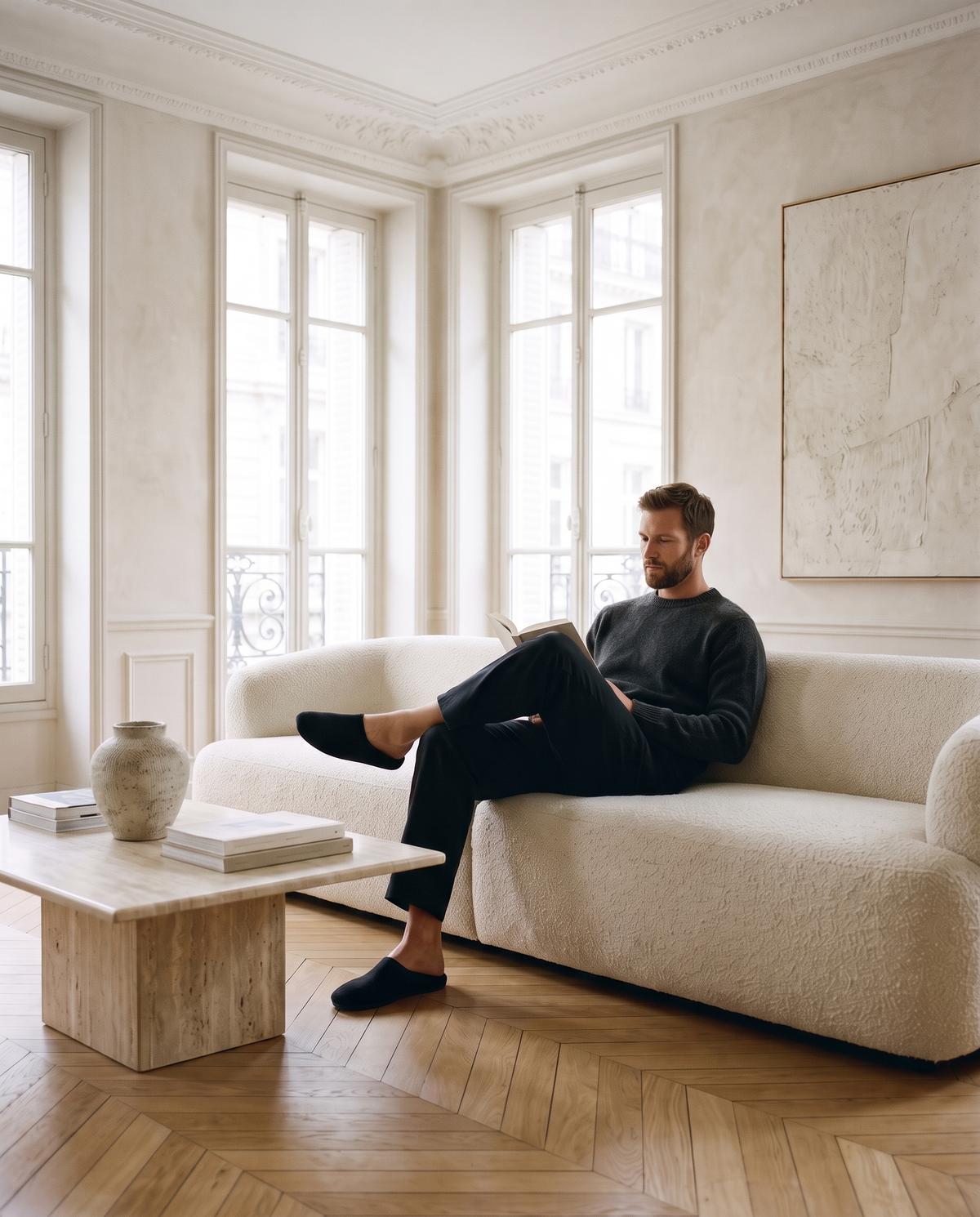 Homme lisant sur le canapé en chaussons
